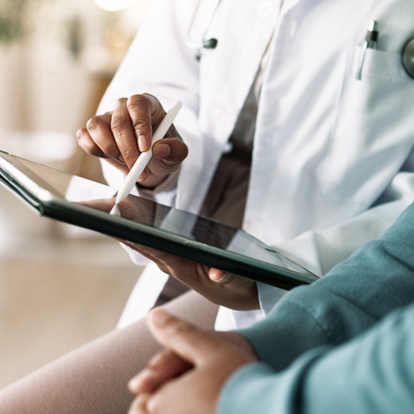Doctor's hands and tablet with patient for consultation