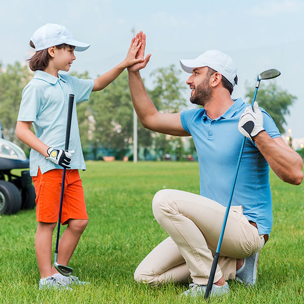 Cheerful young man and his son giving high-five to each other