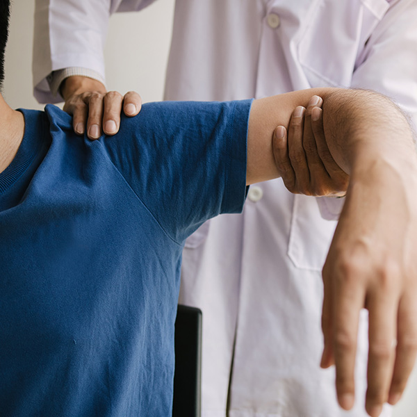 Physical therapists press to the patient shoulder check for pain